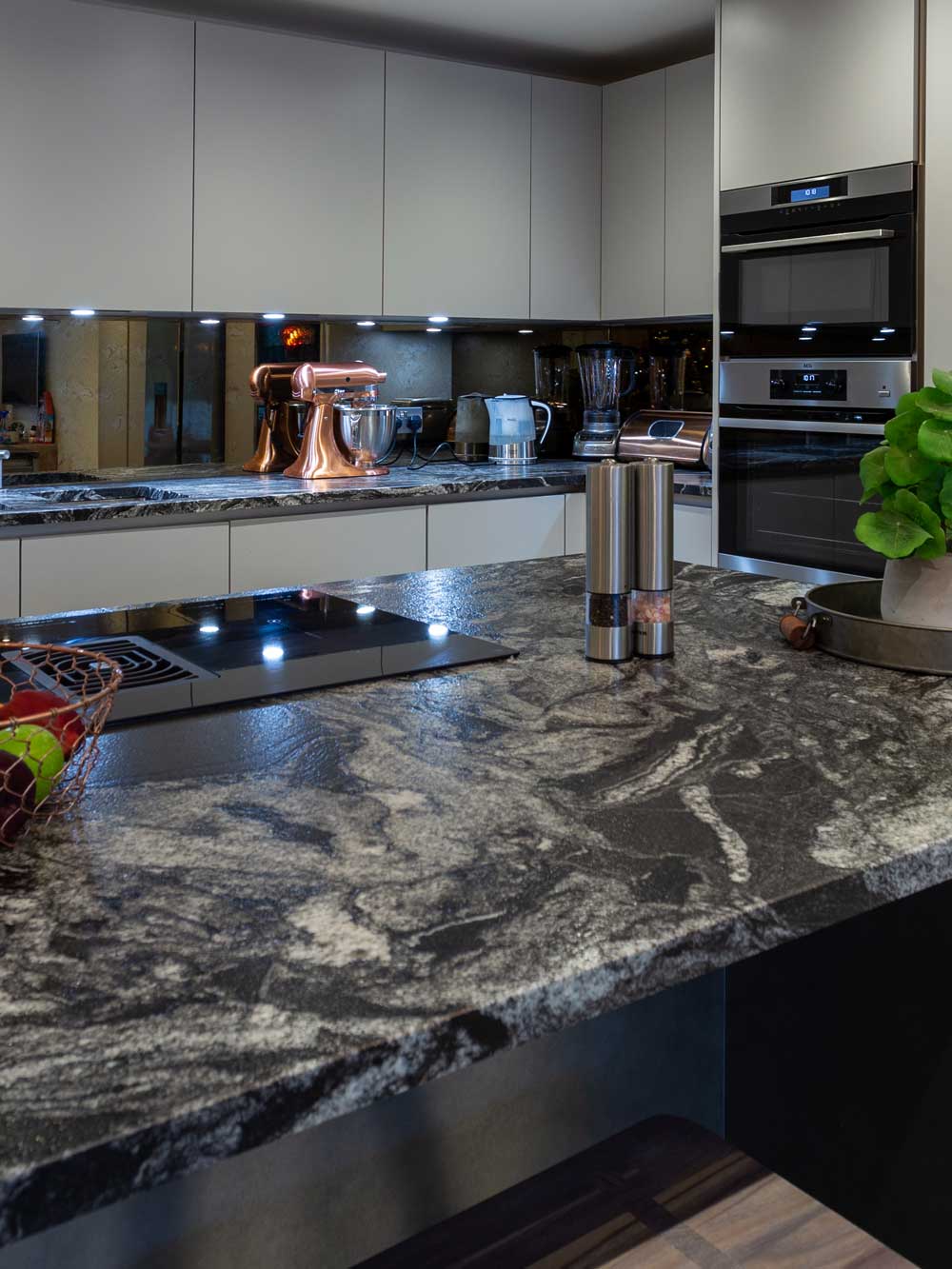 Polished dark granite worktop with undermount sink and drainer grooves
